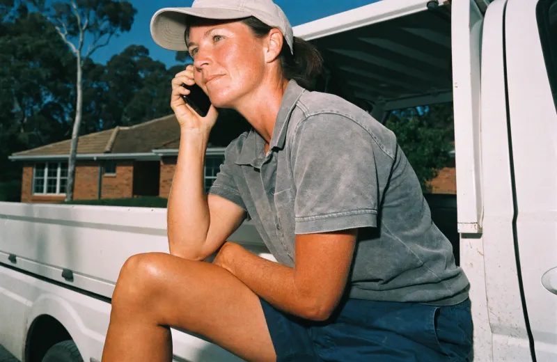 Australian tradesperson sitting in a ute taking a phone call